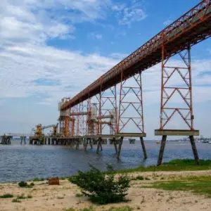 Estrutura metálica portuária sobre rio com pilares treliçados, usada em obra de infraestrutura fluvial